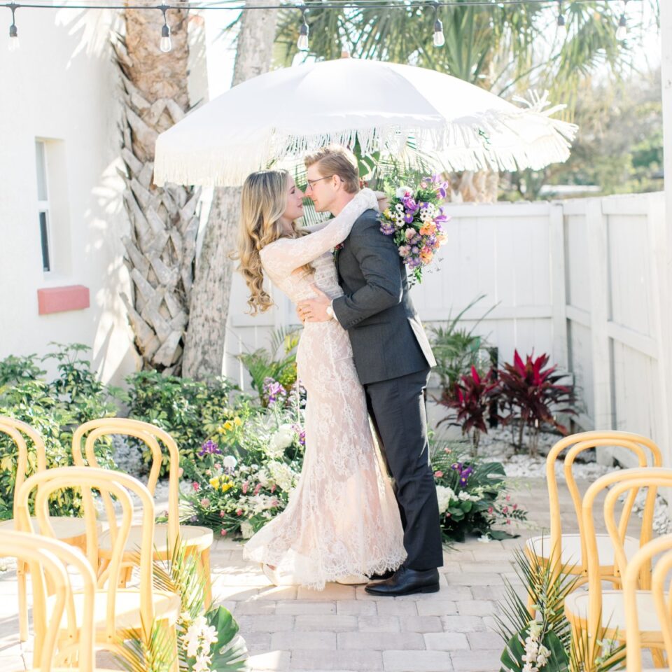 Bride and groom embracing under umbrella at The Local – St. Augustine's small wedding venue